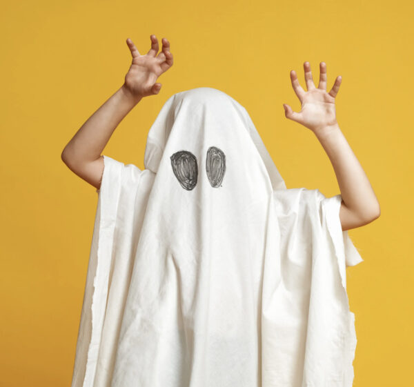 kid dressed as ghost in sheet