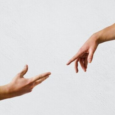 two hands reaching toward each other